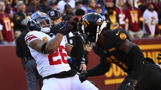 Nov 19, 2023; Landover, Maryland, USA; New York Giants running back Saquon Barkley (26) catches a touchdown past Washington Commanders safety Kamren Curl (31) during the first half at FedExField.